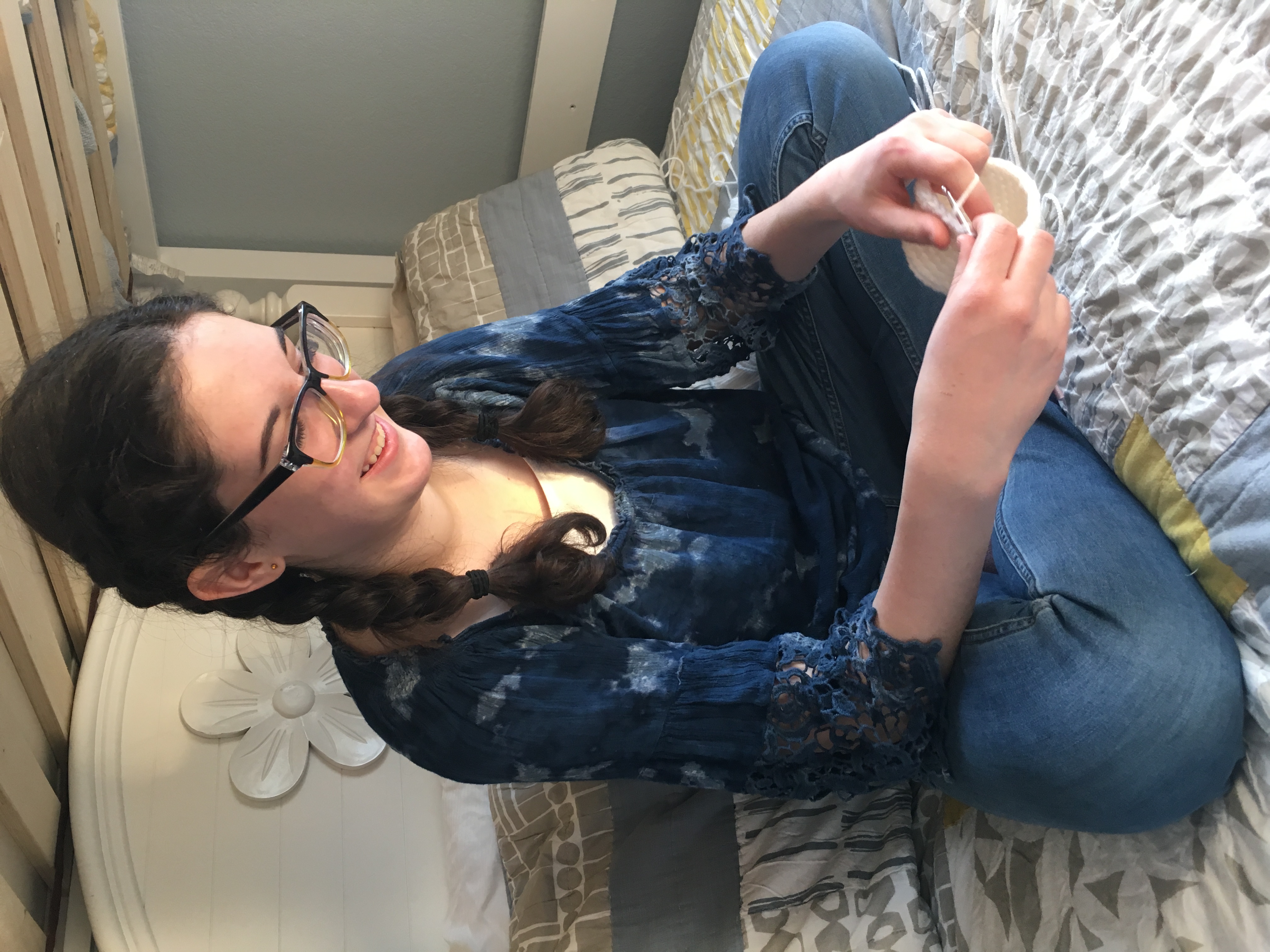 Josephine smiling while crocheting at home